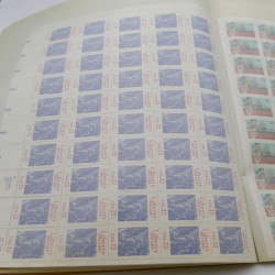 Lot de feuilles entières de timbres du monde en un album.