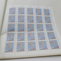 Lot de feuilles entières de timbres du monde en un album.